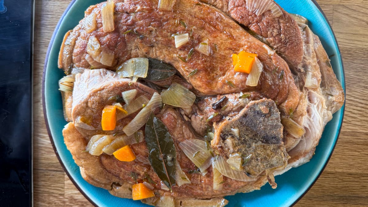 Rouelle de porc braisée prête à être servie dans une assiette bleue