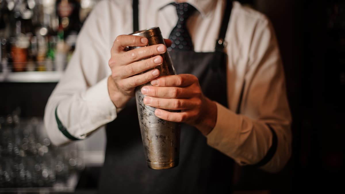 Barman professionnel tenant un shaker en acier
