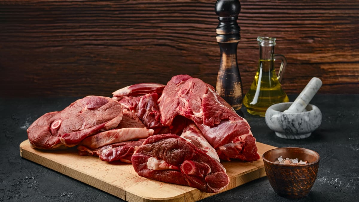 Différents morceaux d'agneau sur planche en bois