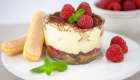 Tiramisu aux framboises en verrine sur assiette blanche