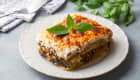 Part de moussaka dans une assiette blanche