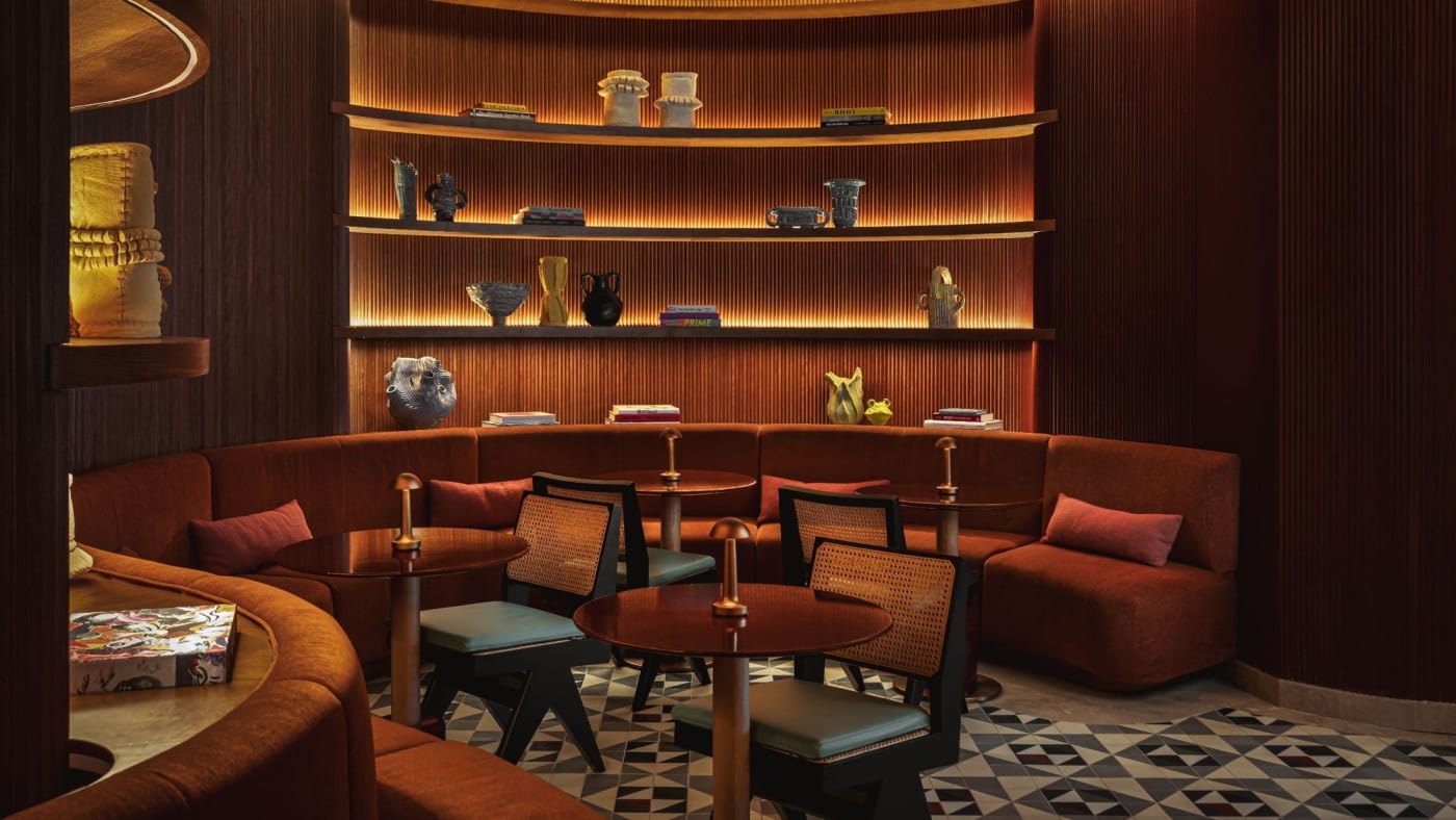 Une banquette cuivrée et des étagères en bois cintrées dans le lounge de l'Andaz Lisbonne