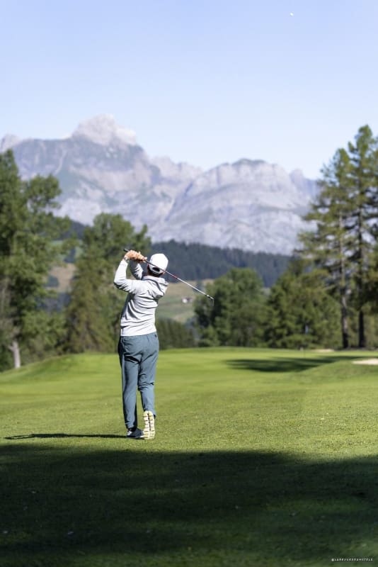 Un golfeur sur le parcours du Mont d'Arbois, à Megève, avec les montagnes en toile de fond