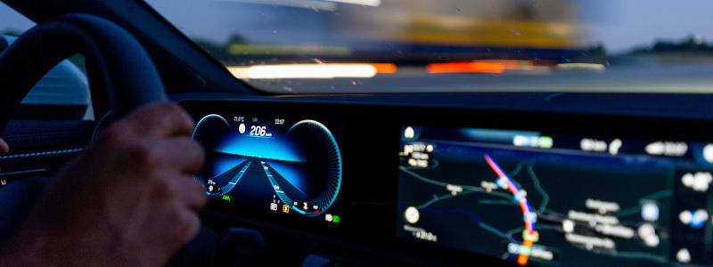 Das Cockpit eines Autos ist bei einer Nachtfahrt erleuchtet inlusive Navigationsdisplay