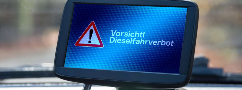 Diesefahrverbote kommen - welche Abgasnormen erfüllt ihr BMW? Navigationsgerät in einem Auto zeigt Fahrverbot Warnung an