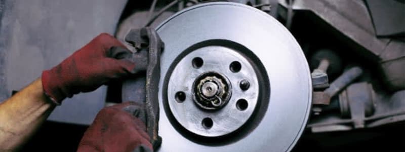 Bremsearbejde på en Hyundai En mekaniker pudser bremseskiven