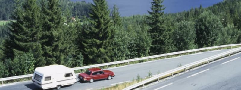 Bil med campingvogn i bjerge Hvor hurtigt må man køre med campingvognen på ferie?