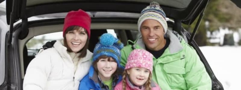 Familie på skiferie i bil Biltur i vinterferien
