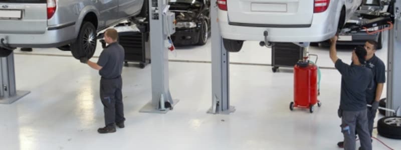 Mekanikere tjekker biler, der er hejst op på lift