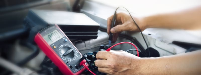 Elektrisk arbejde på en Peugeot Mekaniker udfører diagnosticering af Peugeot's elektronik