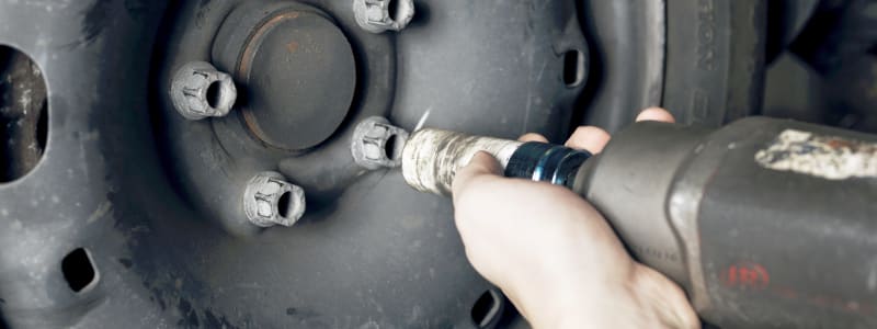 Hjulskifte på bil på værksted Mekaniker skifter hjul på bil