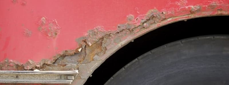 Rød bil med rust Nærbillede af rusten bil