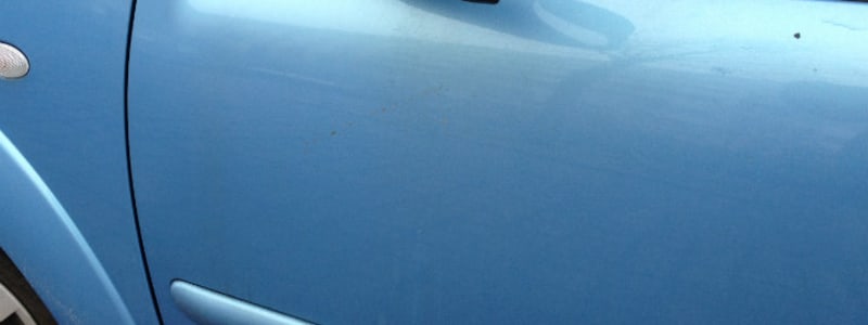 Siden af blå bil Småskrammer og flyverust kan være svært at se på en bil