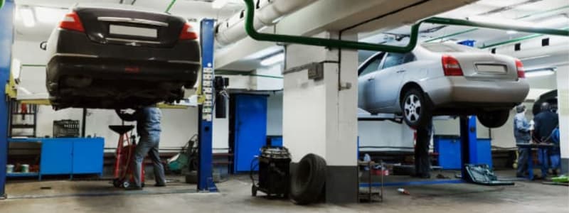 Biler på værksteder Mekaniker arbejder på to biler på værksted