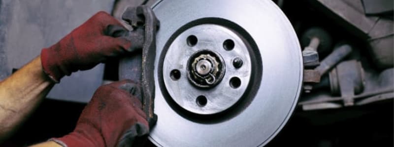Mekaniker skifter bremseklodser på bilen Udskiftning af bilens bremseklodser