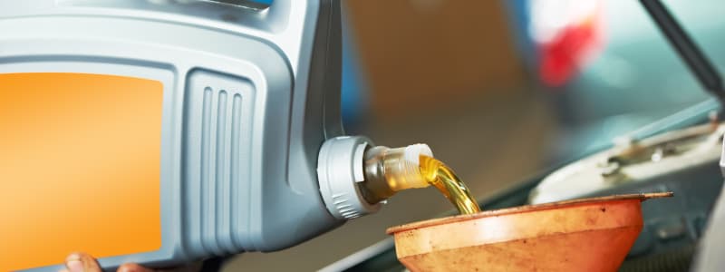 Combien coûte la vidange d'une Hyundai ? Mécanicien mettant à niveau le liquide du moteur