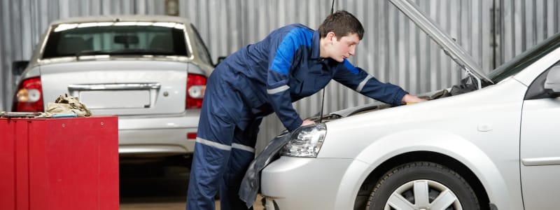 Combien coûte la révision d'une Mercedes ? Mécanicien effectuant la révision d'une voiture