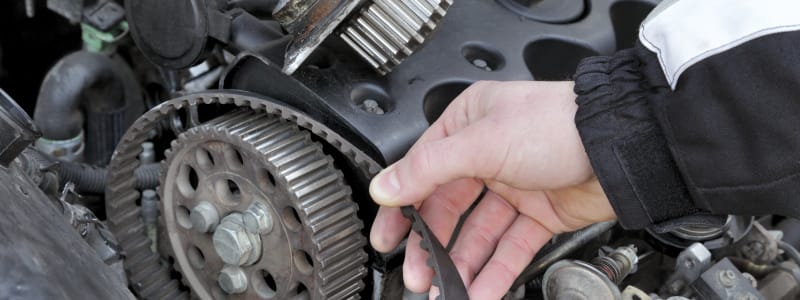 Mécanicien touchant une courroie de distribution