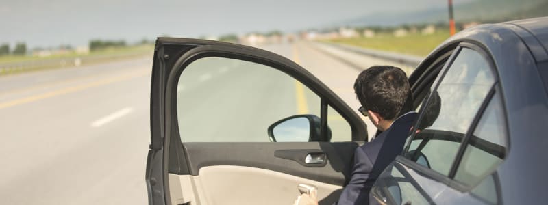 Danger : s'arrêter sur la bande d'arrêt d'urgence de l'autoroute Voiture sur la bande d'arrêt d'urgence, portière ouverte