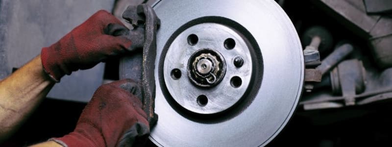 Définition des étriers, disques et plaquettes de frein Mécanicien effectuant un remplacement de freins