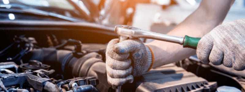 Réparation du moteur d'une Mazda Mécanicien réparant le moteur d'une voiture