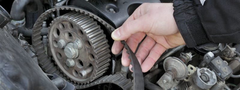 Bilägare rör kamrem i bilens motor