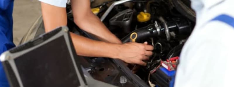 Mekaniker fixar bil som underkänts på besiktning Bil på verkstad efter besiktning