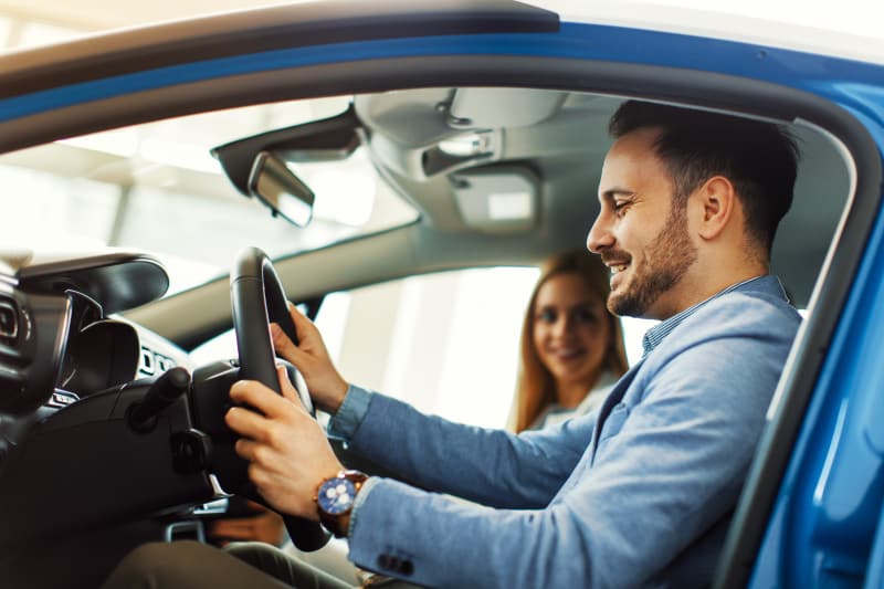 Acheter une voiture d'occasion : quels sont les bons réflexes à avoir ? homme dans sa nouvelle voiture