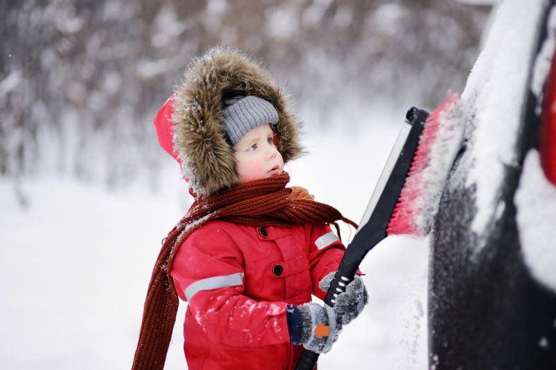 Les accessoires automobiles à avoir pour l'hiver Enfant aidant à déneiger une voiture