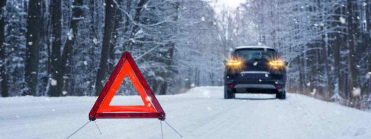 Advarselstrekant på sneklædt vej