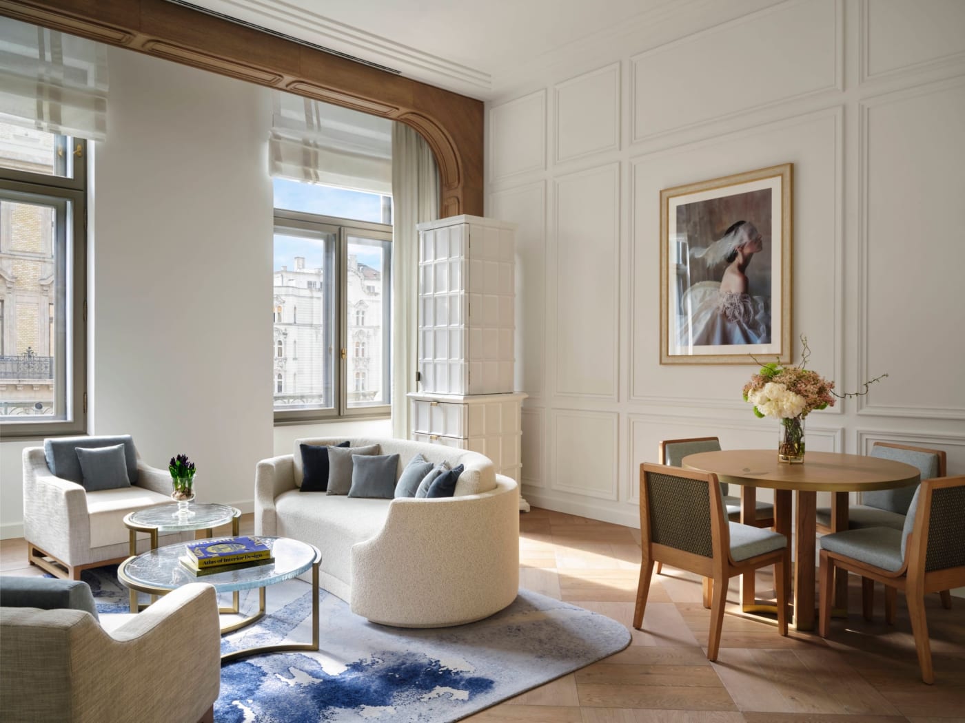 The living room of an Executive Suite at The St. Regis Budapest, with a tiled stove and city-view windows