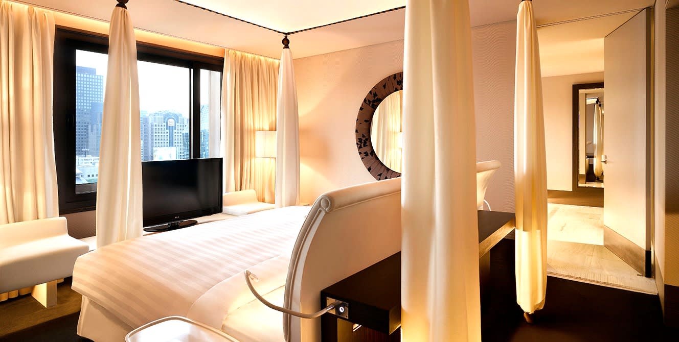La suite presidencial del hotel The Plaza en Seúl, cama con dosel de gasa y vistas al centro
