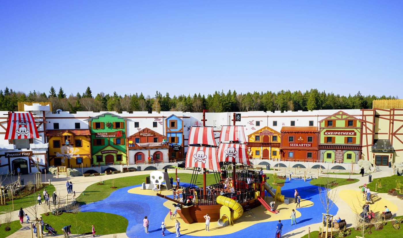 Colourful façades of the Pirateninsel Hotel and the playground pirate ship at Legoland Deutschland