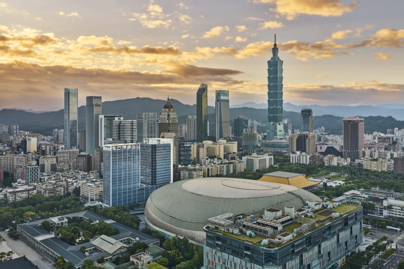 Aerial view of Taipei at sunset, with the Taipei Dome and Taipei 101 tower in the Xinyi district