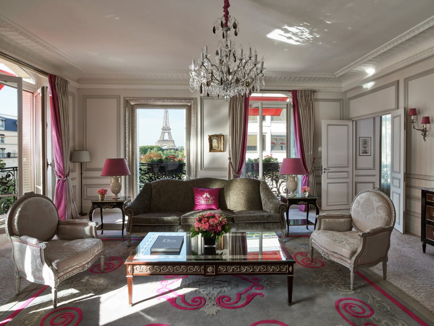 The living room of the Eiffel Suite at the Hôtel Plaza Athénée in Paris, with a crystal chandelier and a view of the Eiffel Tower