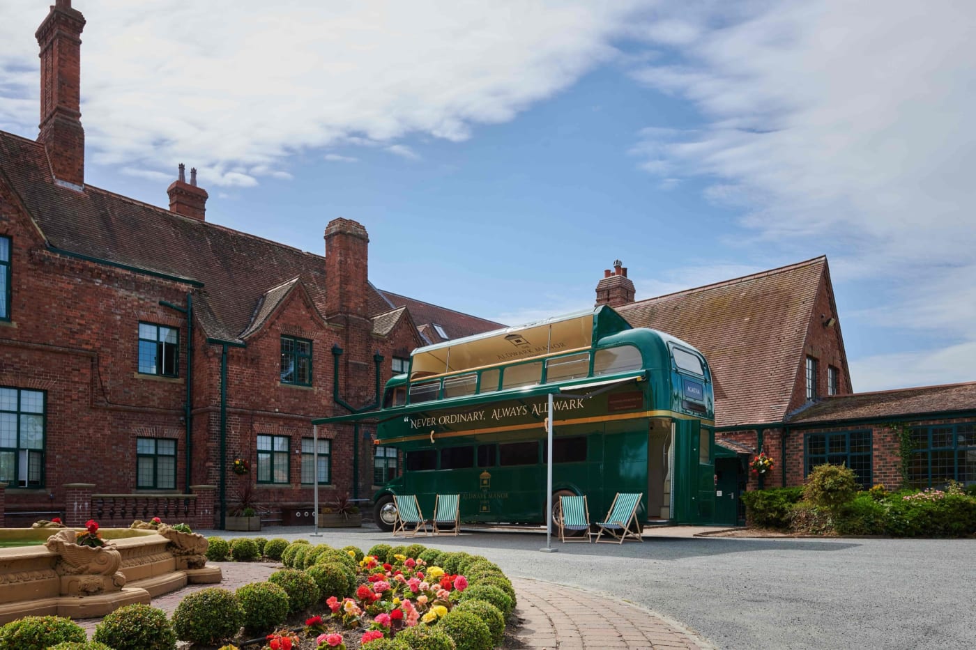 Ônibus Routemaster de 1964 adaptado diante da mansão do Aldwark Manor Estate