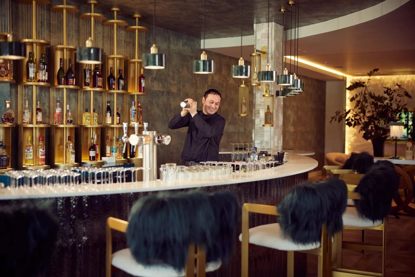 Bar de l'hôtel Van der Valk Nuland avec barman et étagères dorées