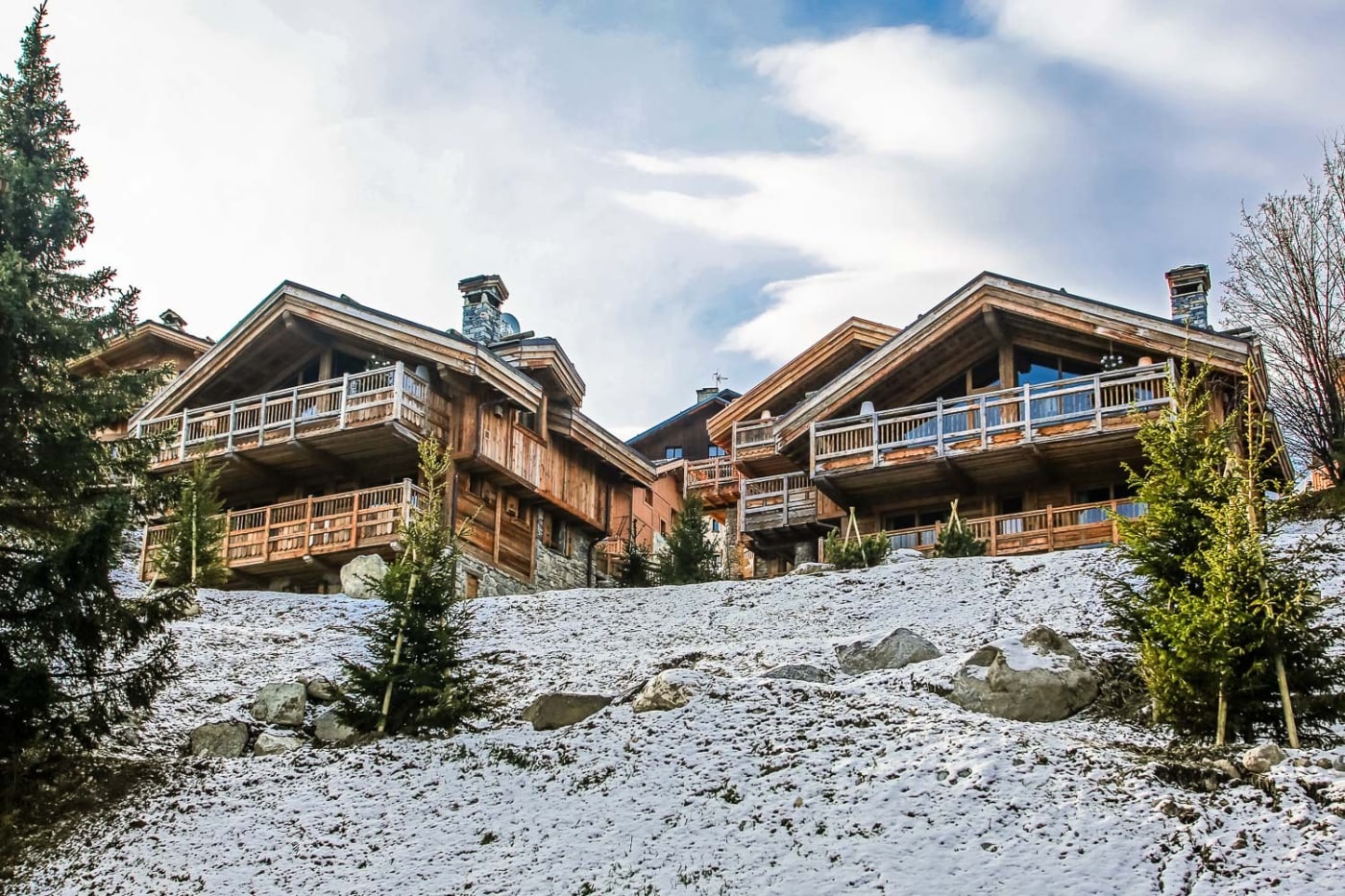 Holzchalets an einem verschneiten Hang in Courchevel, Savoyen