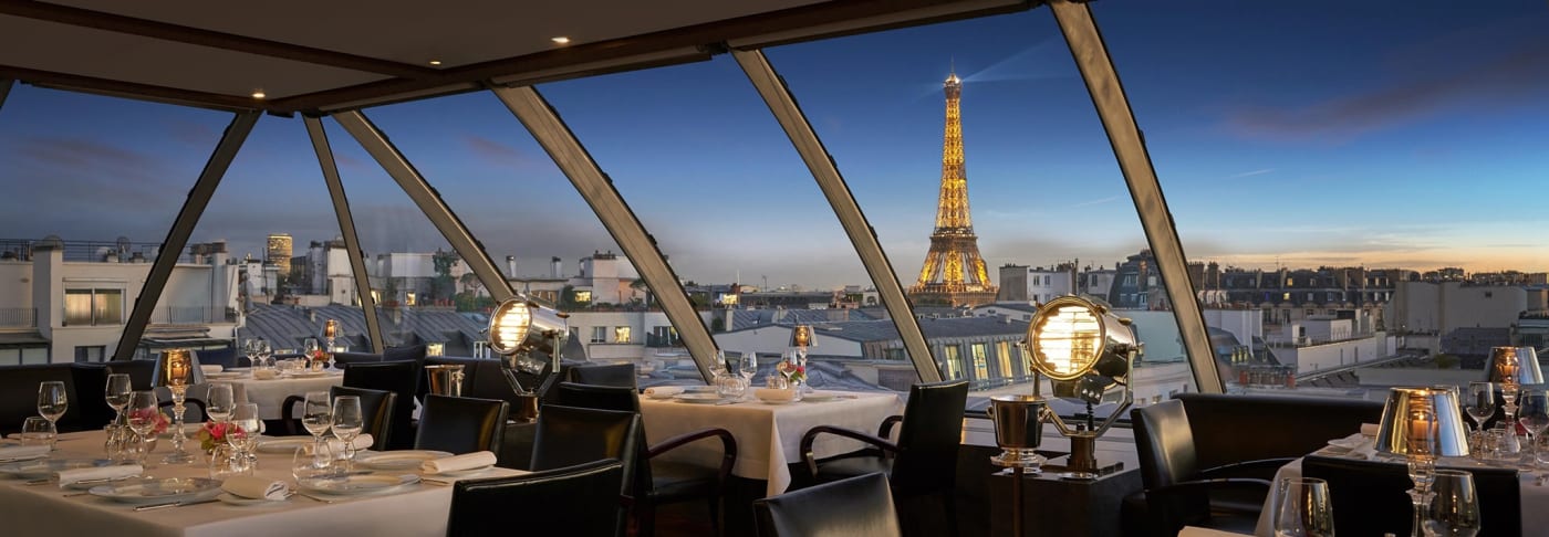 Le restaurant L'Oiseau Blanc sur le toit du palace The Peninsula Paris, face à la tour Eiffel illuminée