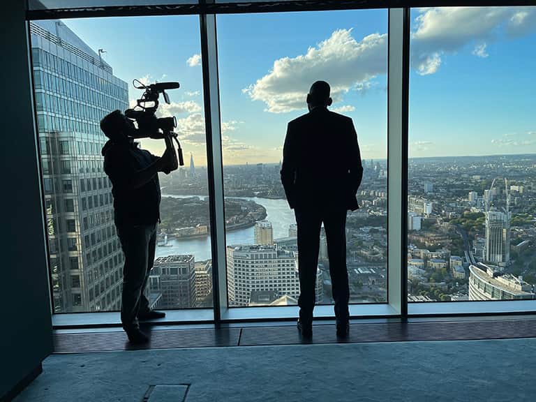 A camera operator filming by a window