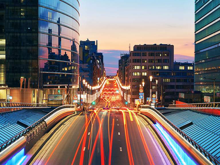 A city avenue at dusk with traffic light trails