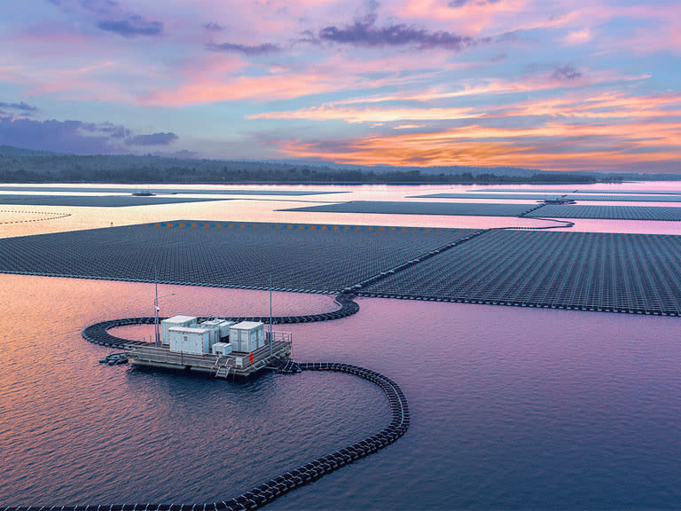 Floating solar panels on water at sunset