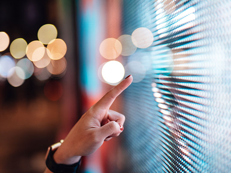 A hand touching an illuminated screen