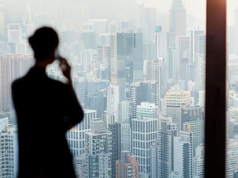 A business traveller using a mobile phone in a city
