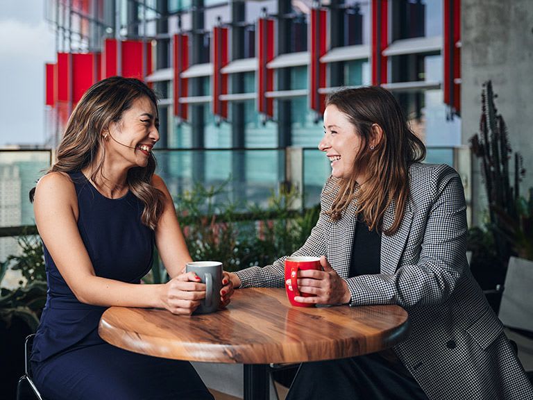 Two colleagues in conversation over coffee