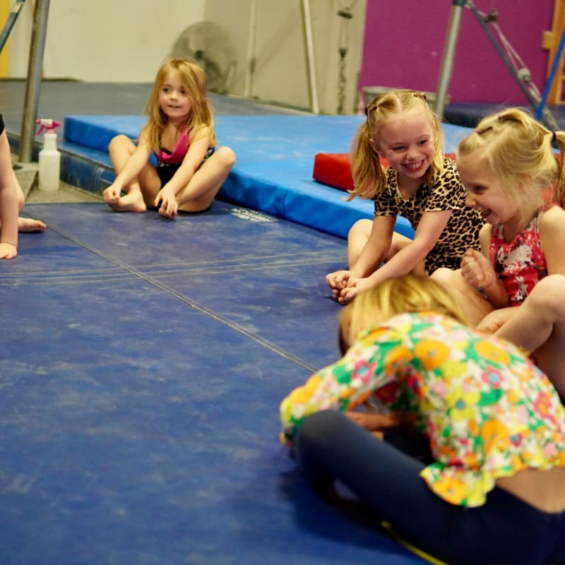 a group of girls sitting on a mat