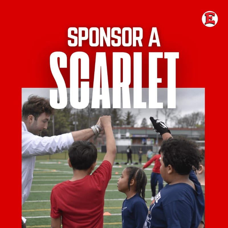 A coach gives a high-five to a group of children on a sports field, with a red background featuring the words "SPONSOR A SCARLET" and a logo.