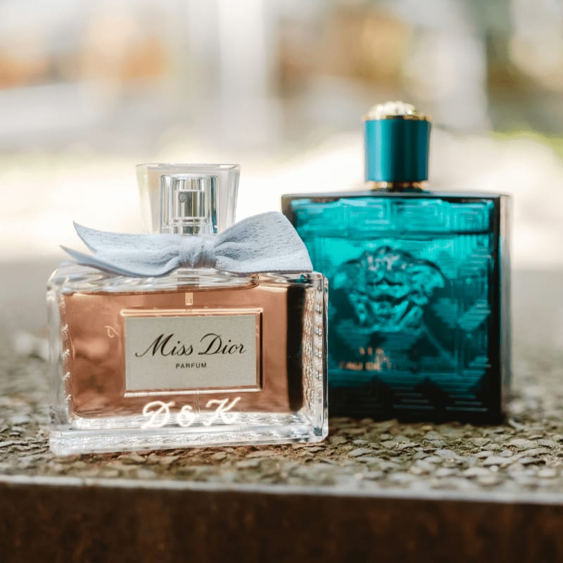 Two perfume bottles on a stone surface.