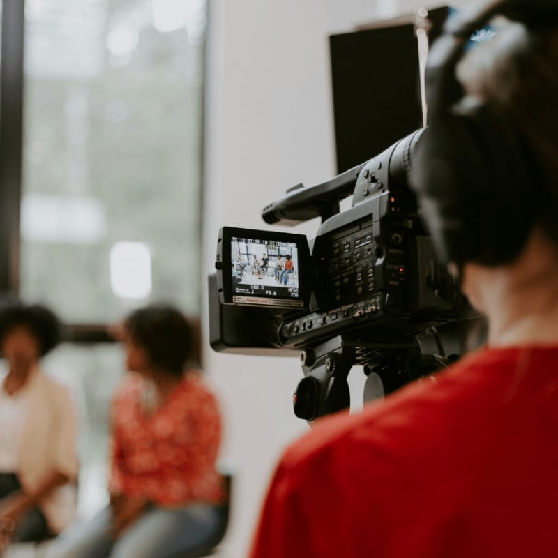man in red shirt holding black video camera