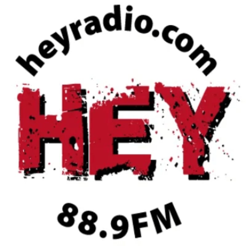 Bold red letters spelling "HEY" with black splatters are in the foreground, while "heyradio.com" arches above and "88.9FM" sits below.